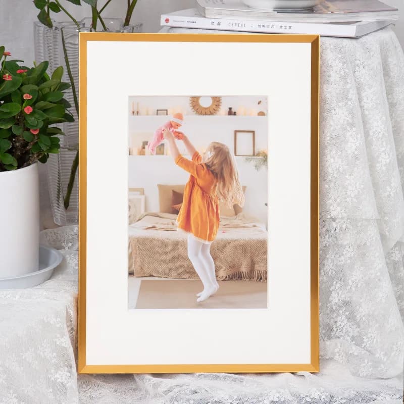 Quadro de decoração com moldura dourada e imagem de menina em ambiente doméstico
