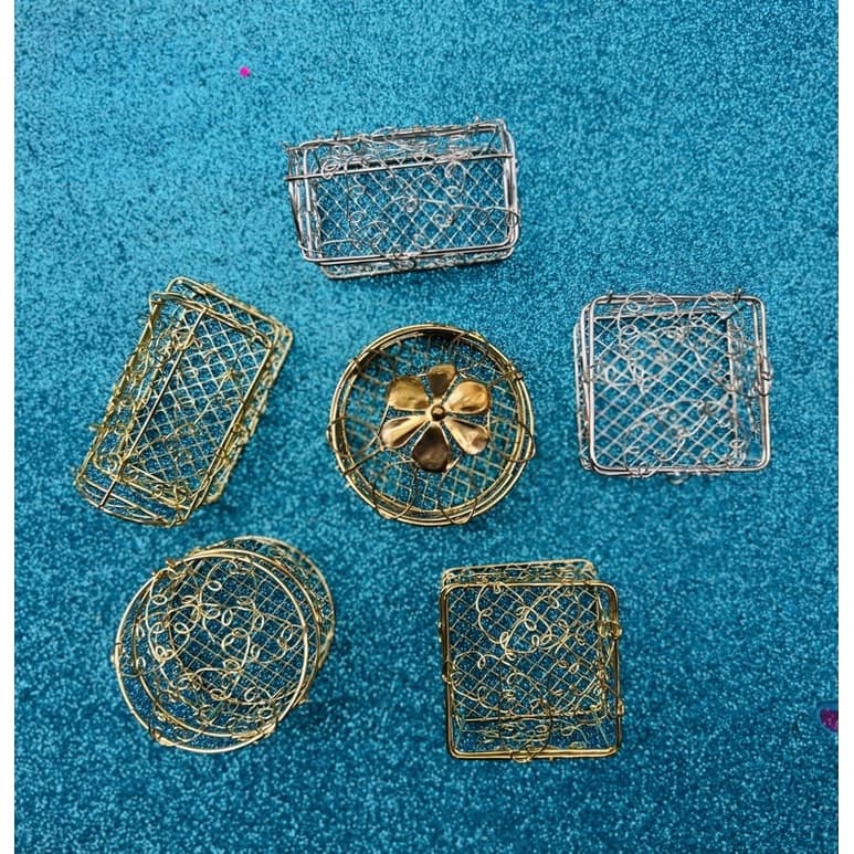 Caixas de metal arame vazado dourado e prata sobre fundo azul