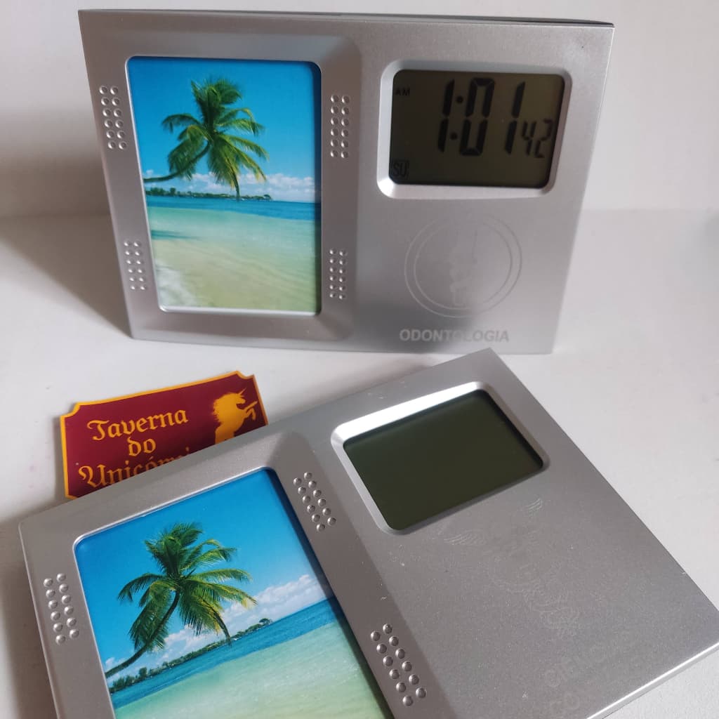 Porta retrato com relógio digital, imagem de praia com palmeira, fundo branco