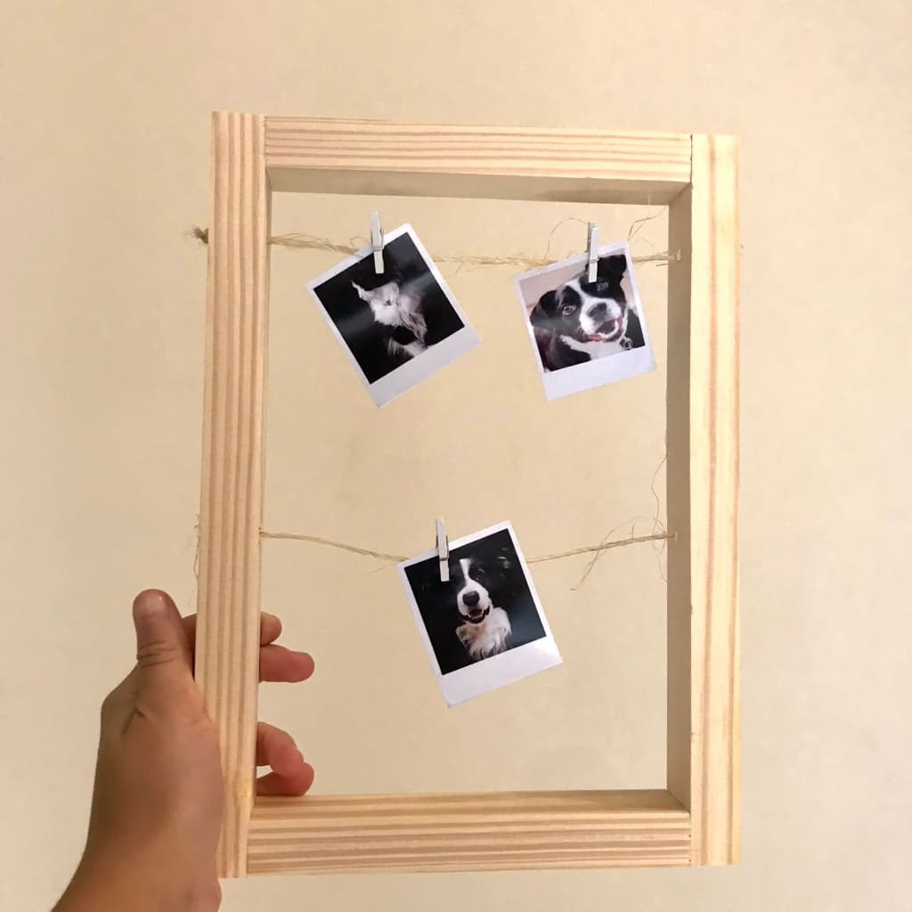Porta retrato minimalista com três fotos de cães penduradas em cordas de sisal