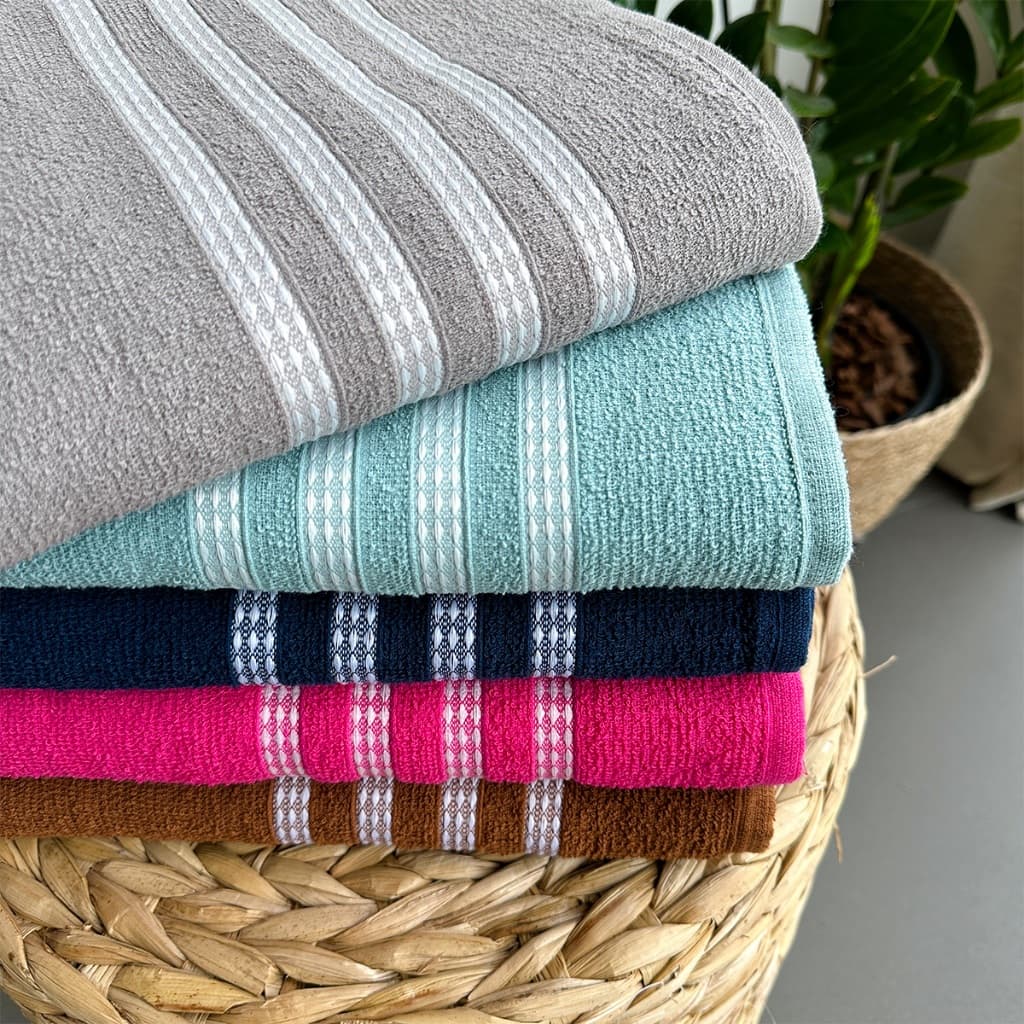 Conjunto de três toalhas de banho dobradas em cores sortidas em um cesto de vime