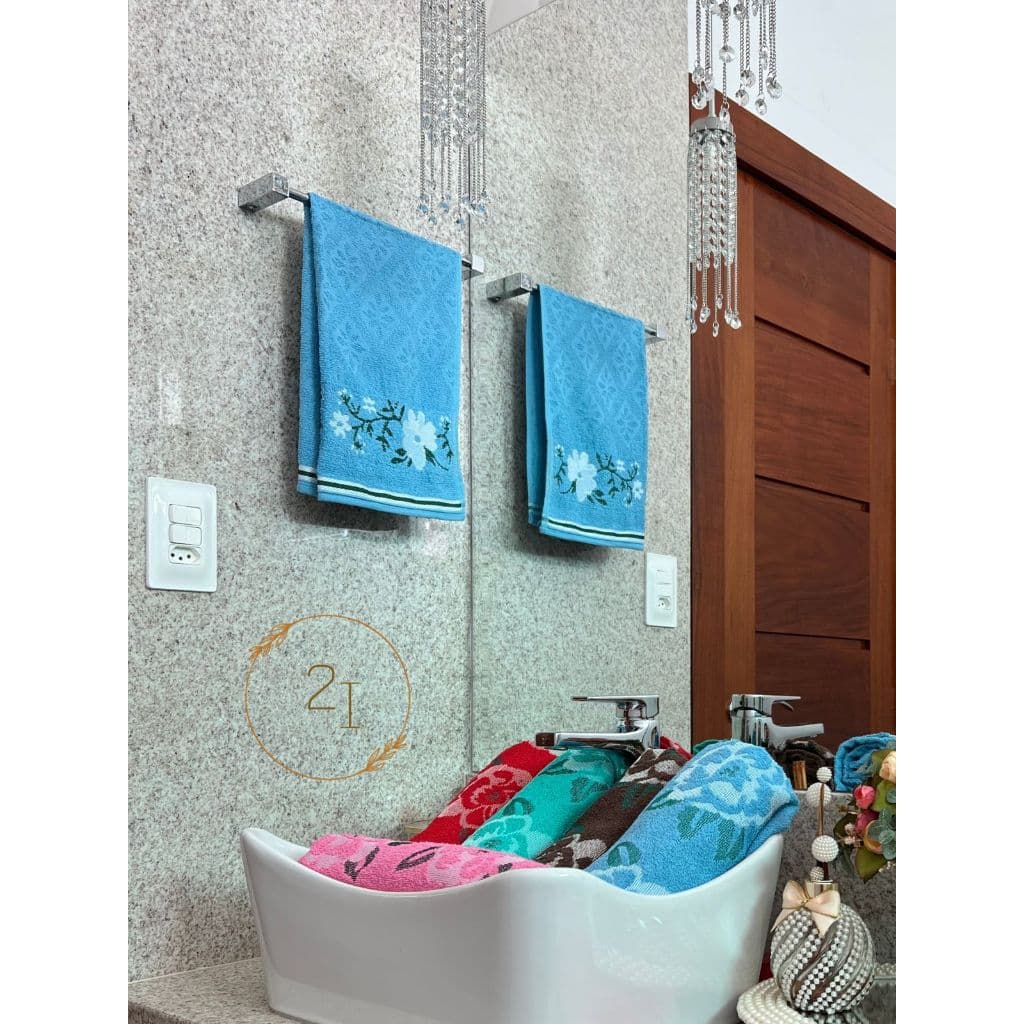 Toalha azul com padrão floral pendurada em suporte de banheiro