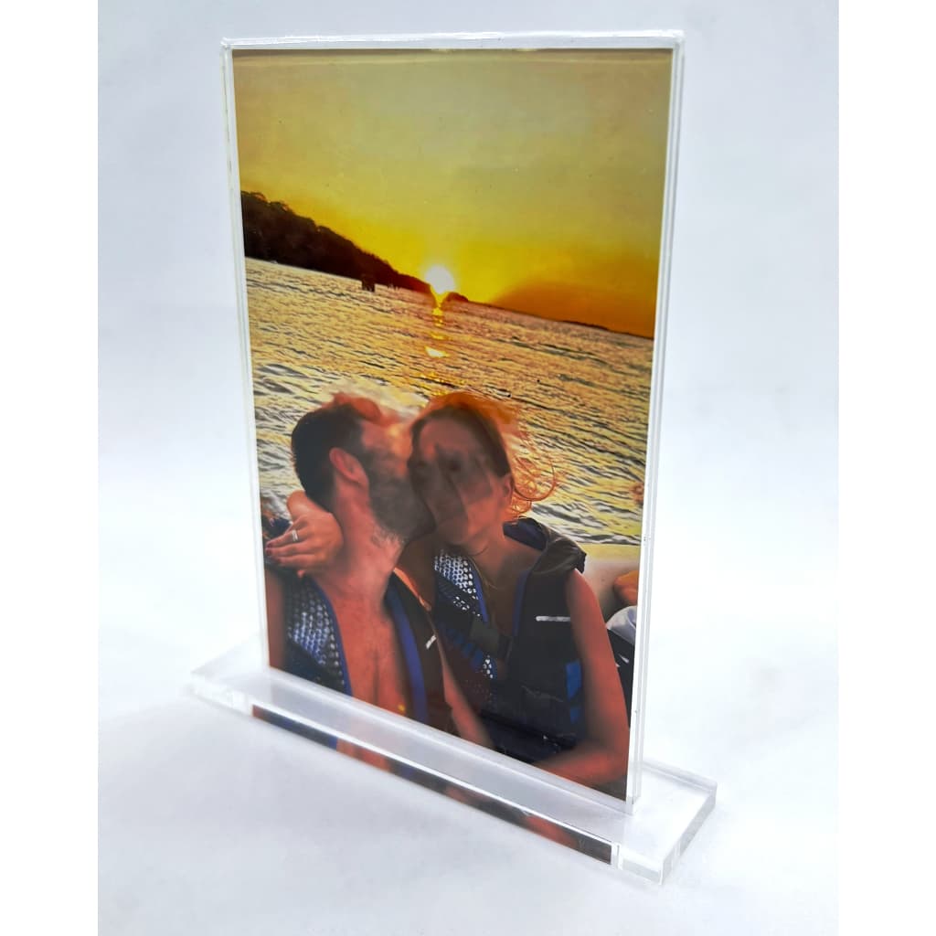 Porta retrato acrílico transparente vertical com foto de casal ao pôr do sol