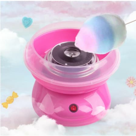 Mini máquina de algodão doce rosa em funcionamento com algodão doce multicolorido