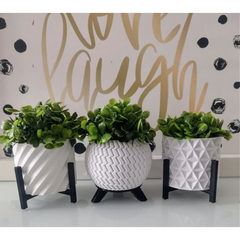 Kit de 3 cachepôs brancos com plantas artificiais em fundo com frase Love Laugh