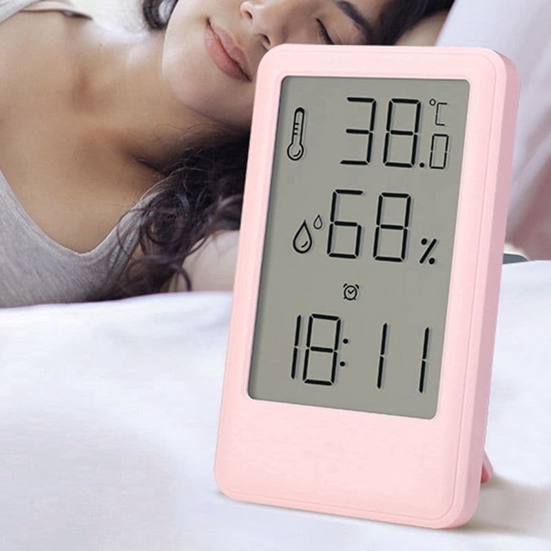 Relógio digital rosa com higrômetro e termômetro, mostrando 38°C, 68% de umidade e hora 18:11.