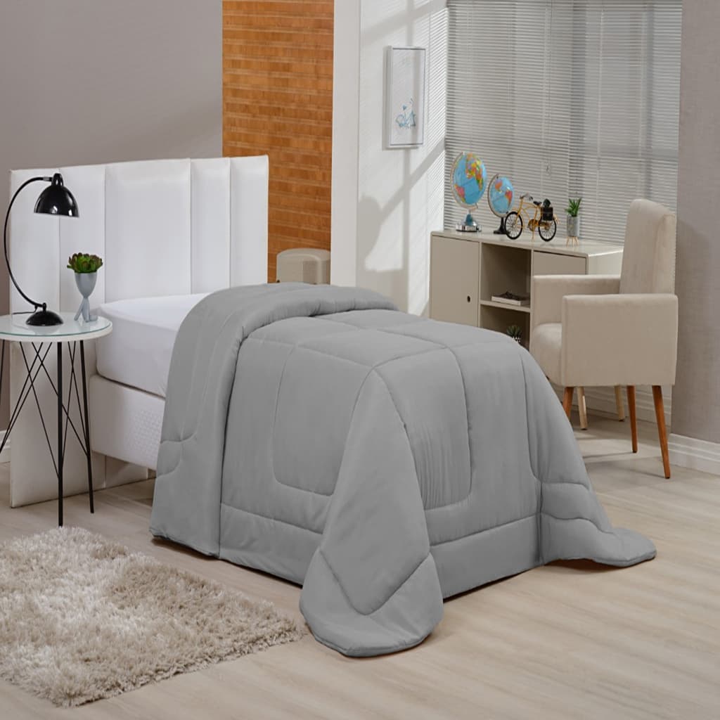Edredom solteiro cinza claro sobre cama de solteiro em quarto com decoração minimalista