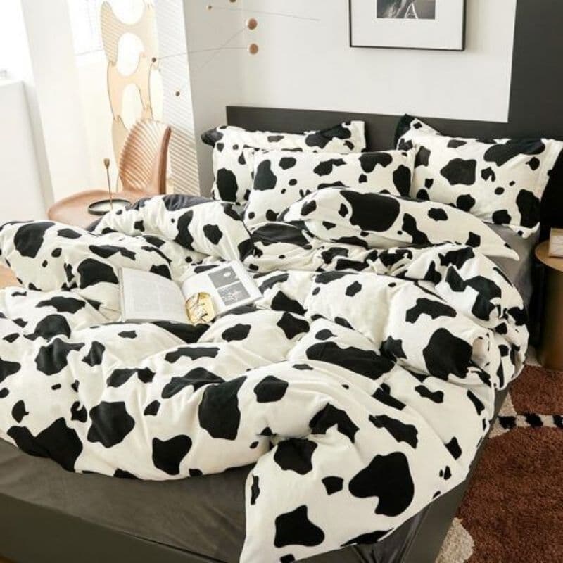 Edredom de casal com estampa de vaca preto e branco em um quarto moderno