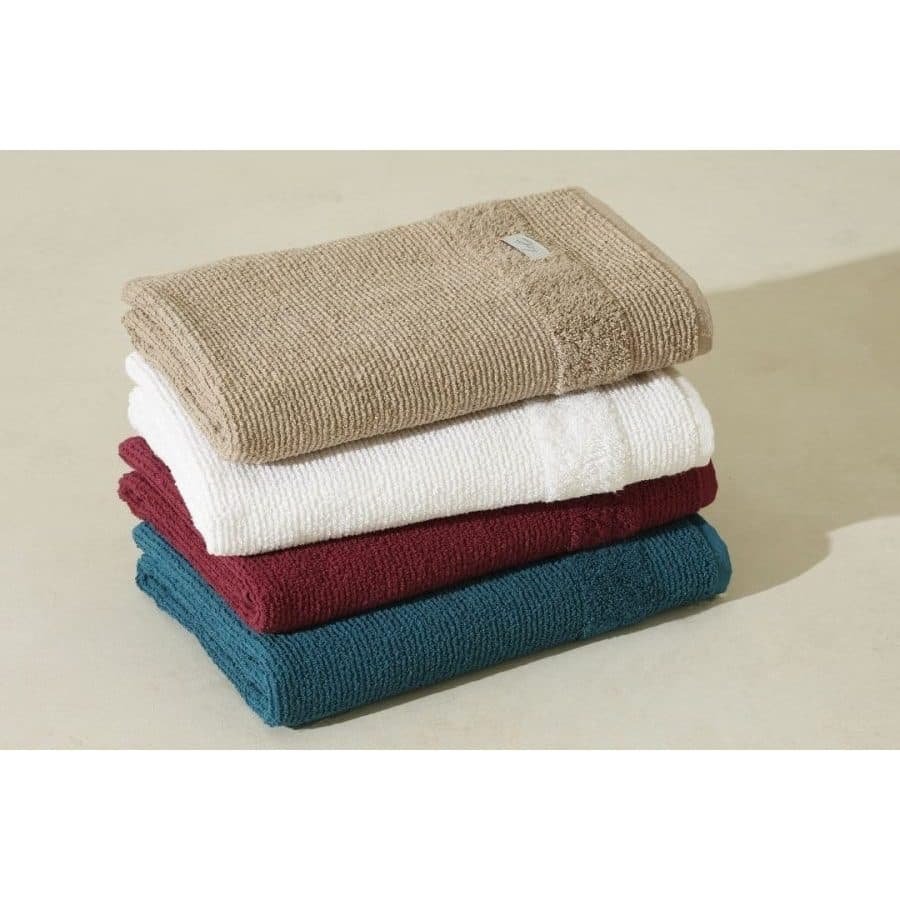 Pilha de toalhas de banho em tons bege, branco, vermelho e azul