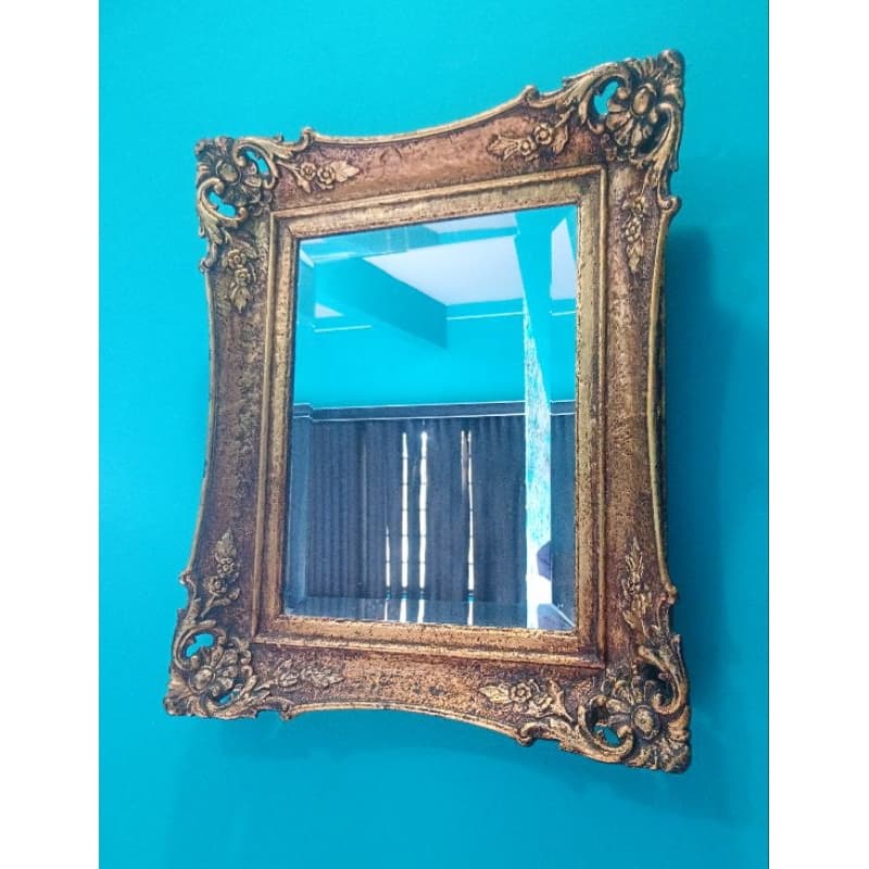 Espelho vintage dourado com moldura floral em parede azul