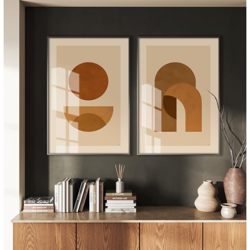 Quadros decorativos escandinavos com formas redondas e arqueadas em marrom e bege, pendurados em uma parede cinza.