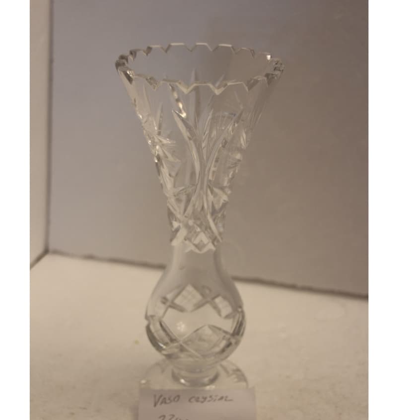 Vaso de cristal transparente com padrão geométrico, 22 cm de altura, boca larga, fundo cinza.