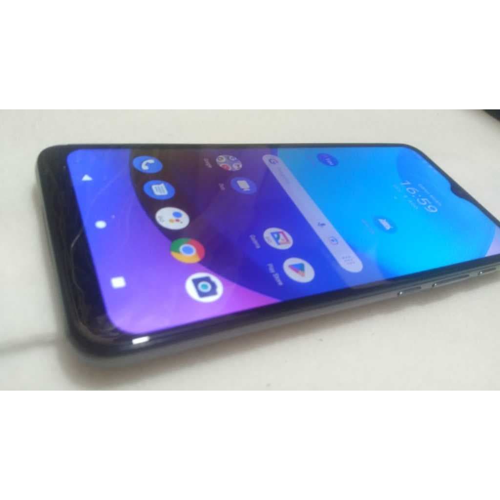 Celular Moto E20 preto com tela azul exibindo interface do usuário