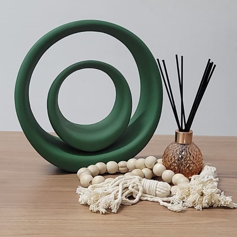 Kit decorativo com dois vasos verdes em forma de espiral e aromatizante em fundo branco