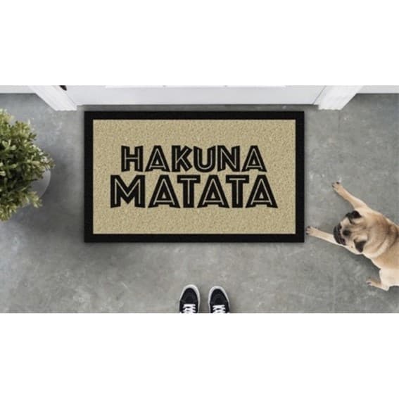 Tapete temático Rei Leão com texto 'HAKUNA MATATA', fundo bege, borda preta