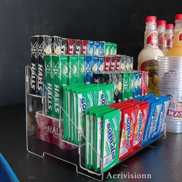 Expositor acrílico transparente para esmalte e doces com vários produtos coloridos