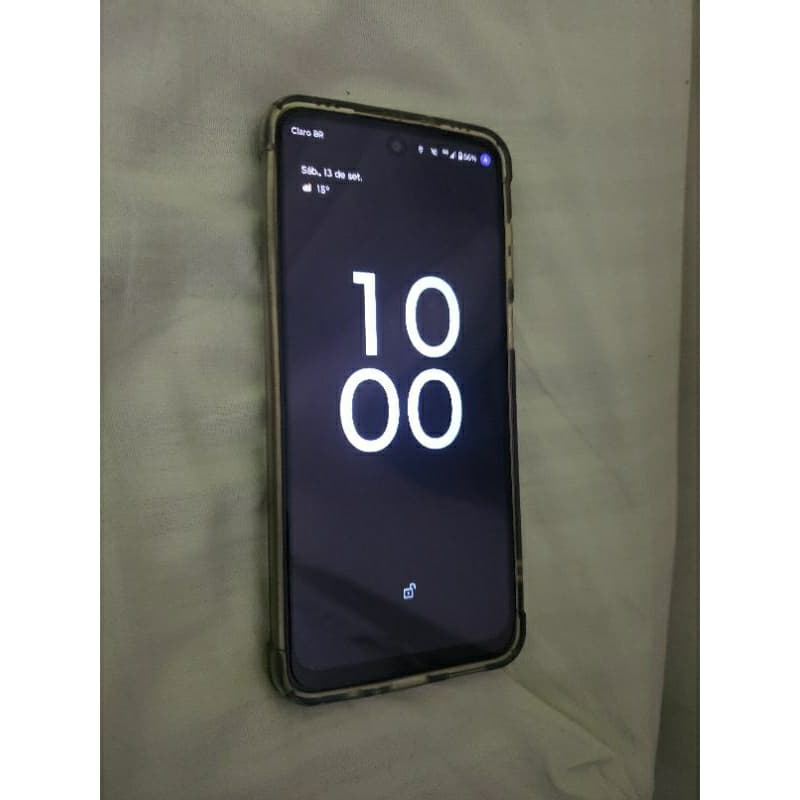 Moto G53 5G smartphone em fundo cinza, tela desligada mostrando a hora 10:00, textura camuflada na parte traseira