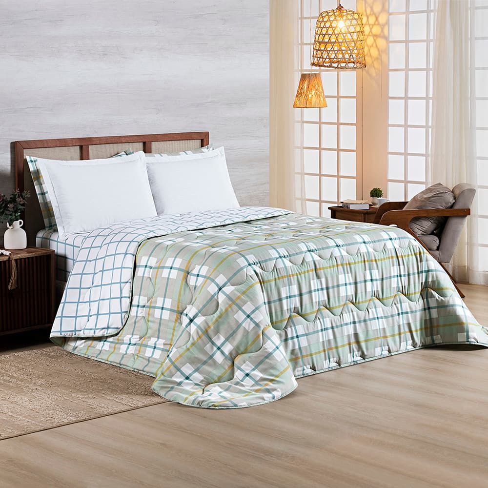 Edredom verde e branco xadrez em cama com travesseiros brancos, quarto com piso de madeira e parede cinza