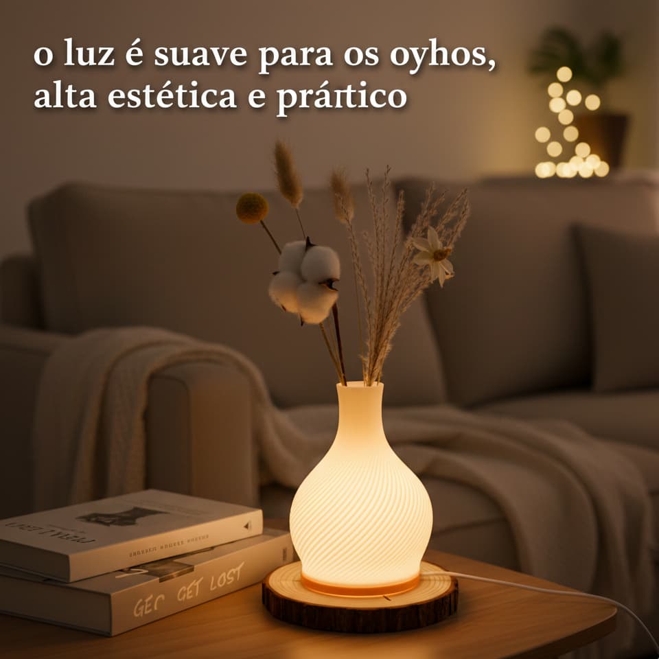 Lâmpada de mesa em forma de vaso com arranjo de flores secas, iluminada, em uma mesa de madeira com livros