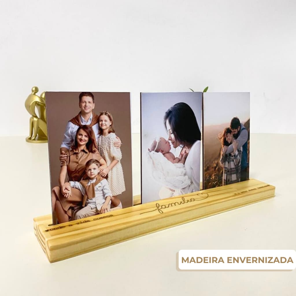 Suporte de madeira envernizada com três porta-retratos de 10x15 cm, cada um mostrando uma foto de família, texto 'família' gravado.