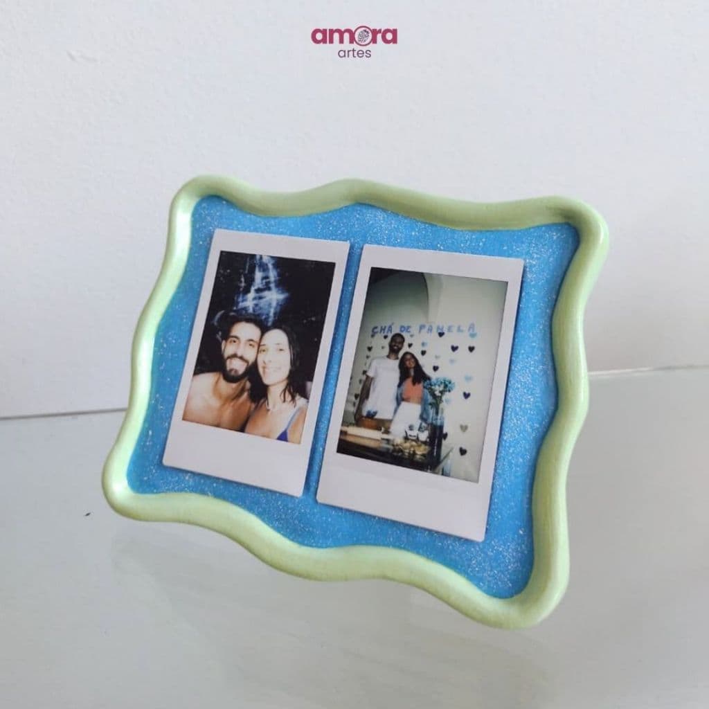 Porta-retrato artesanal de cerâmica para duas fotos Polaroid Instax, com borda verde e fundo azul.