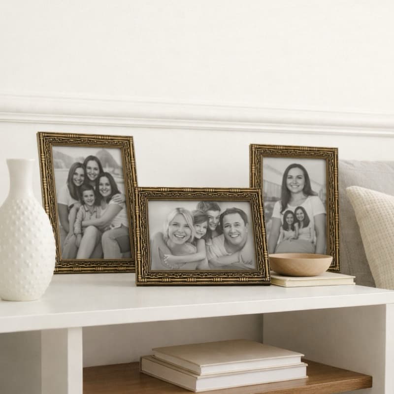 Porta-retratos dourados com fotos de família em preto e branco em um suporte branco