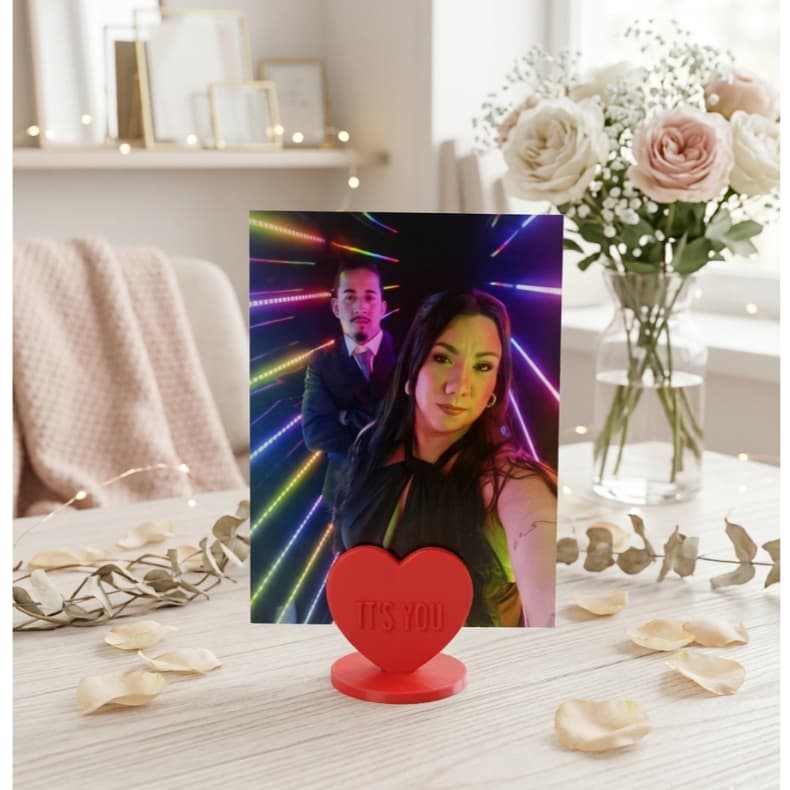 Porta-retrato em forma de coração vermelho com foto de casal e texto 'It's You' em fundo minimalista