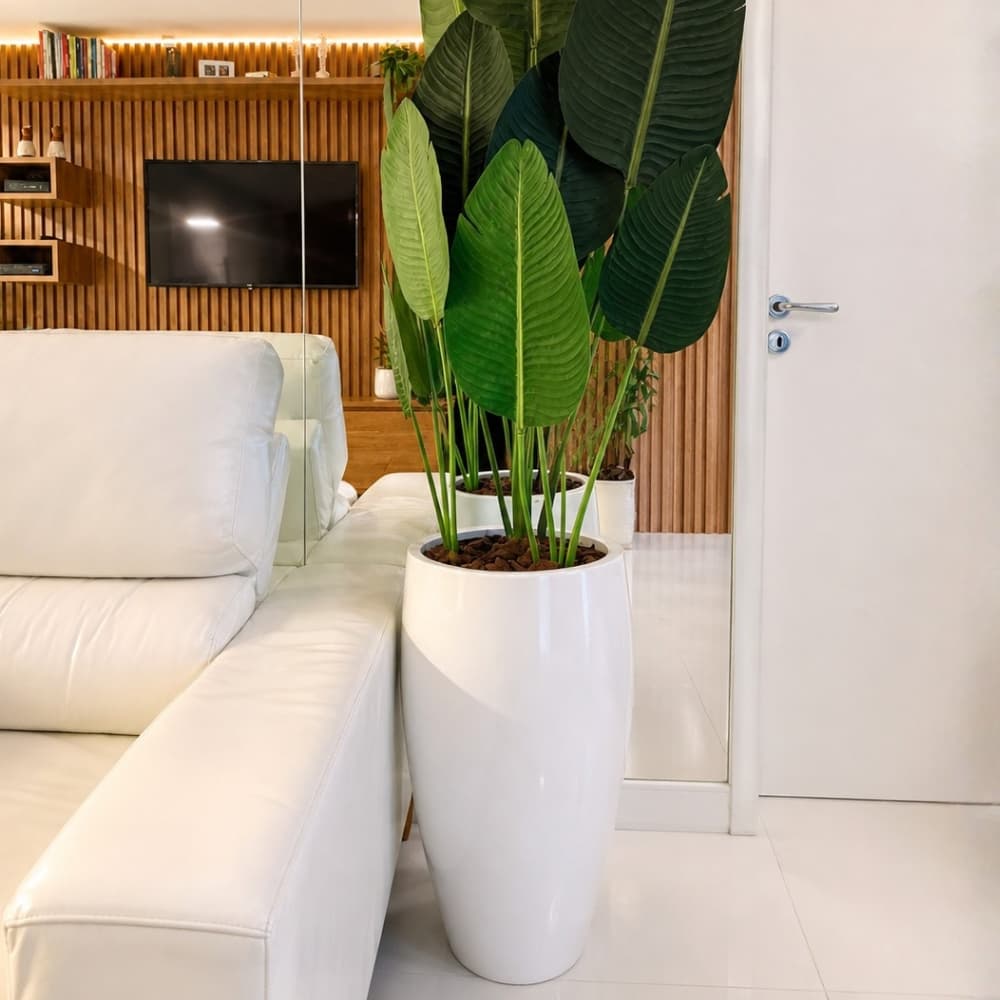 Vaso de fibra de vidro branco com planta verde em sala de estar