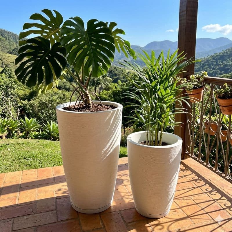 Dois vasos de polietileno brancos em forma de cone com plantas em um terraço com vista para montanhas