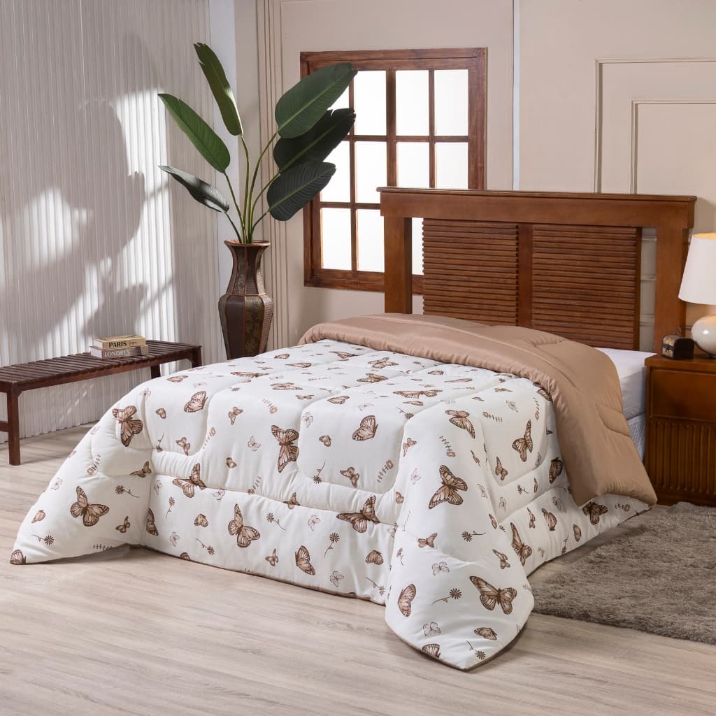 Edredom estampado de borboletas em um quarto com fundo claro.