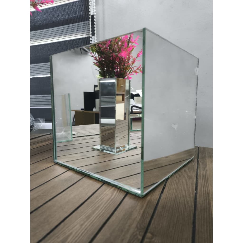 Vaso espelhado decorativo de 20 cm refletindo flor rosa sobre superfície de madeira