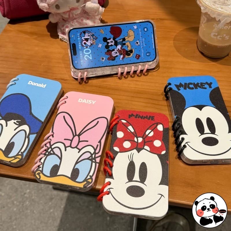 Capas de telefone com desenhos animados da Disney, Mickey, Minnie, Donald e Daisy, sobre uma mesa de madeira
