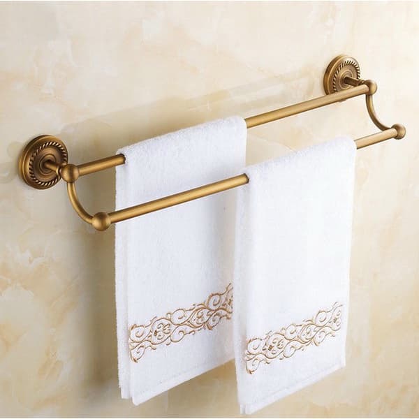 Toalheiro de latão antigo com montagem na parede, trilho duplo e suporte de barra de toalha, com toalhas brancas decoradas em ouro.