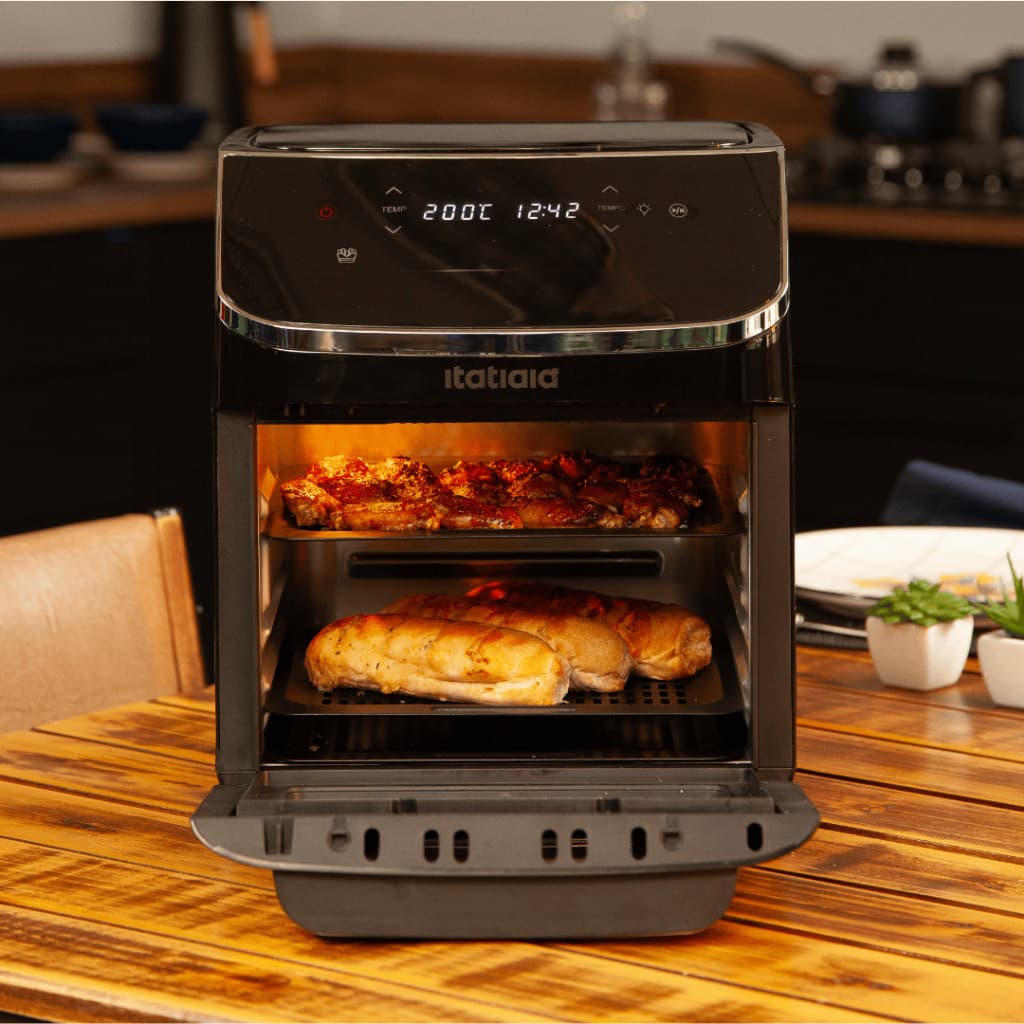 Forno Air Fryer e Desidratador Itatiaia 12L em preto, cozinhando comida em uma mesa de madeira.