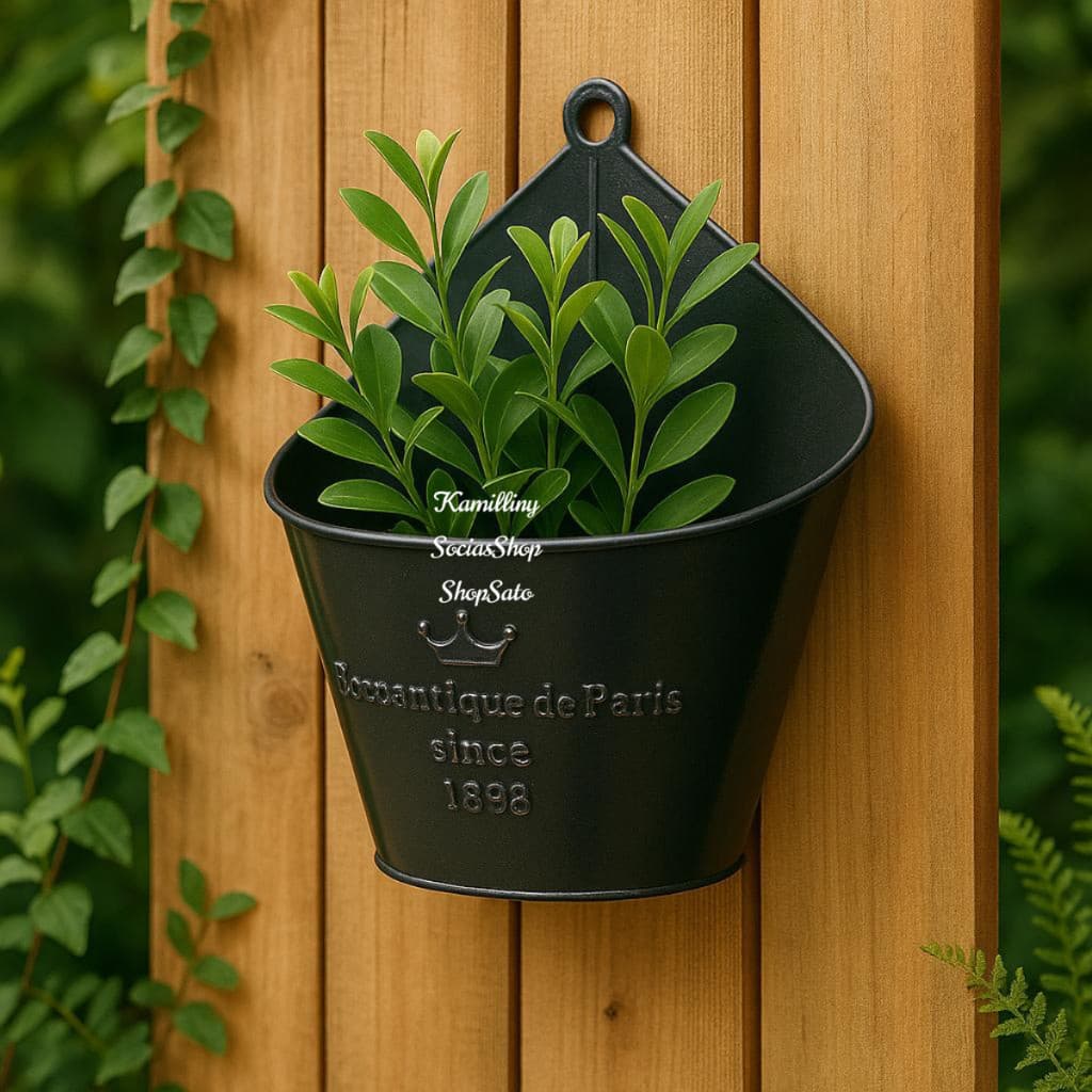 Vaso de metal preto para plantas pendente em parede de madeira com texto 'Bom Antique de Paris since 1898'.