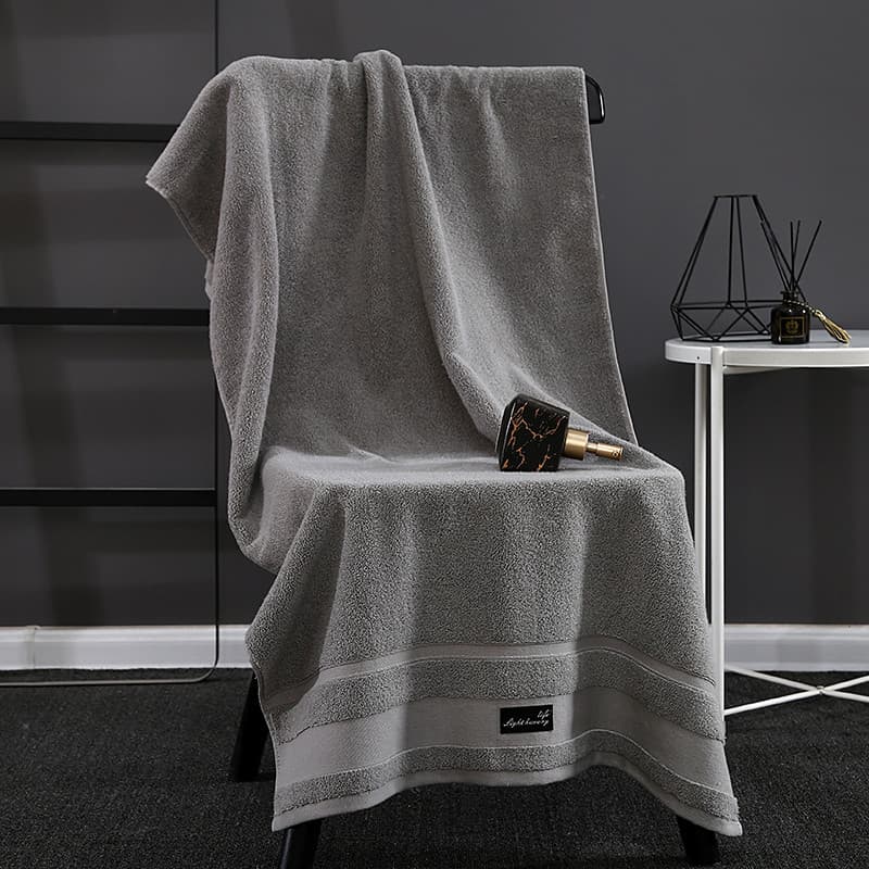 Toalha de banho masculina cinza absorvente com emblema em canto inferior direito