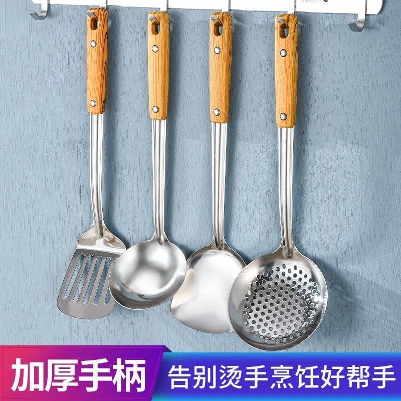 Utensílios de cozinha de aço inoxidável com cabos de madeira pendurados na parede