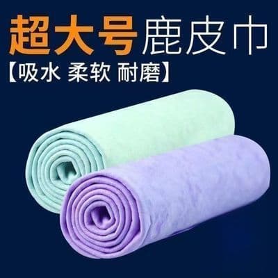 Toalhas absorventes de cabelo enroladas, verde-claro e lilás, sobre fundo azul.
