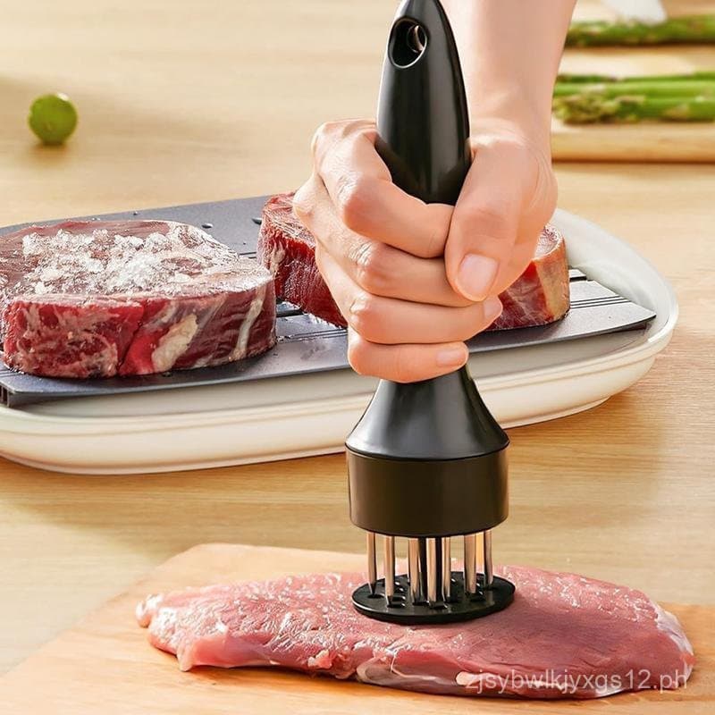 Amaciador de carne em aço inoxidável sendo usado sobre um pedaço de carne