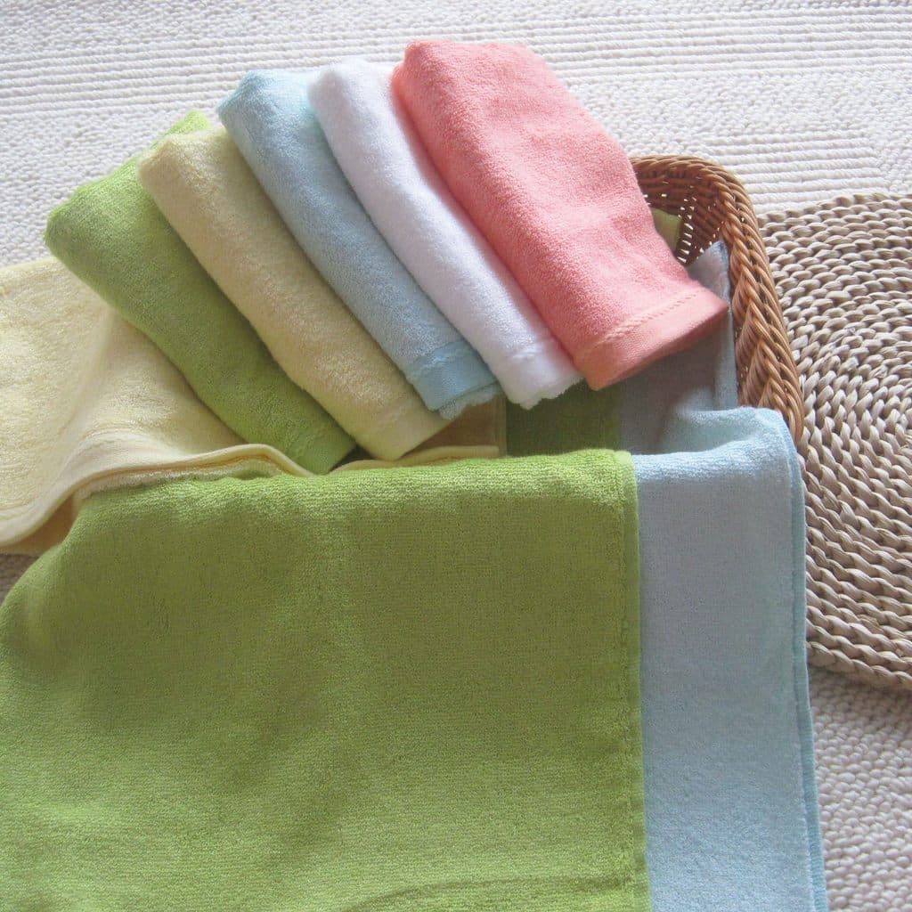 Toalhas de fibra de bambu em cores pastel em um cesto