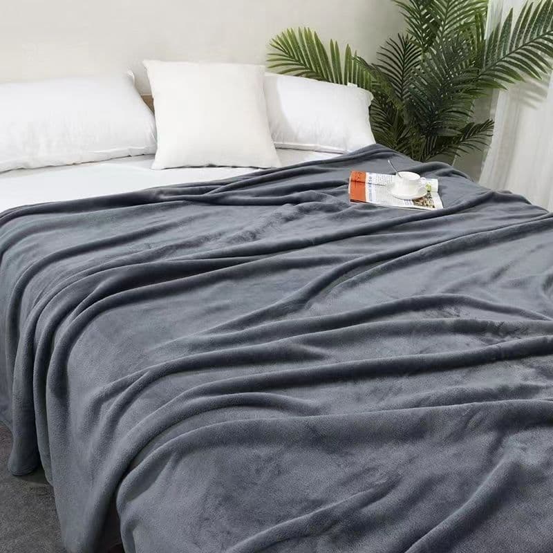 Cobertor de flanela dupla face cinza em cama com almofadas brancas