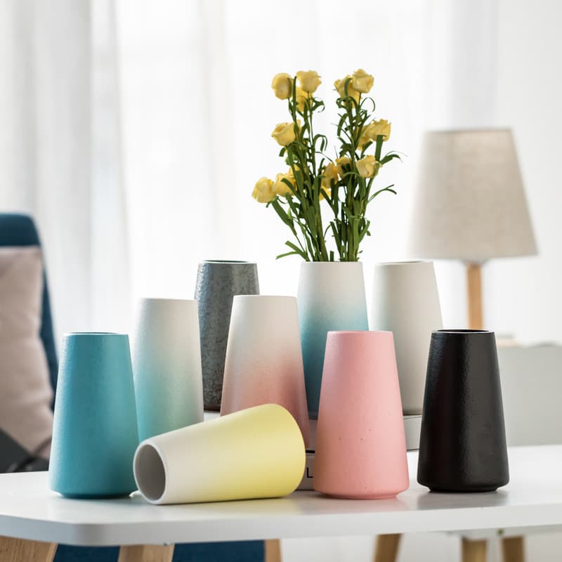 Vasos de cerâmica fosco de boca larga em várias cores em uma mesa