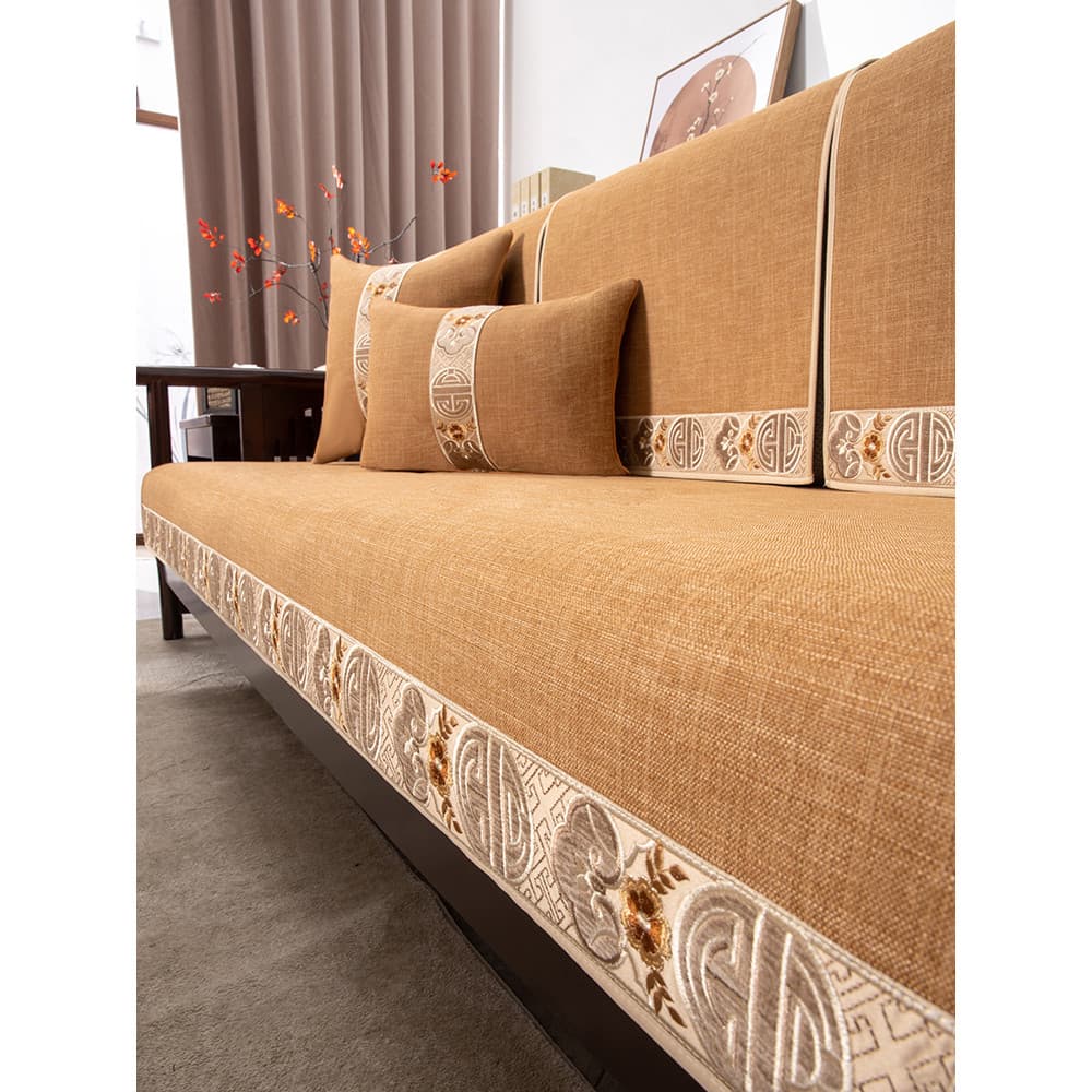 Sofa com almofadas decorativas de estilo chinês em bege com detalhes florais e geométricos
