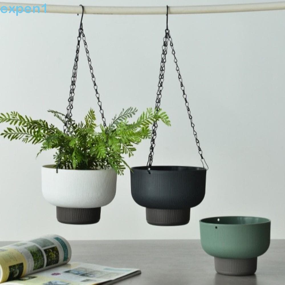 Vasos suspensos de flores branco, preto e verde com plantas verdes