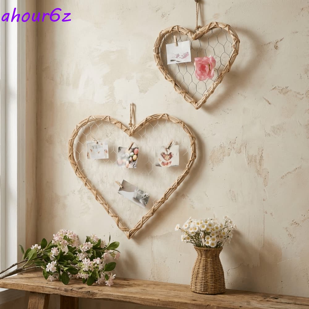 Moldura em forma de coração pendurada na parede com fotos e flores brancas