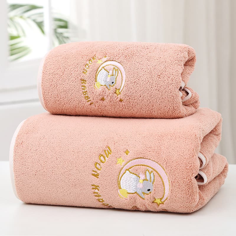 Três toalhas de banho rosa bordadas com desenho de coelha, em fundo branco