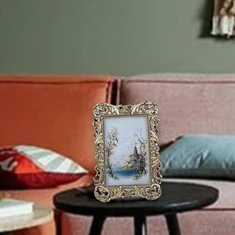 Porta-retratos vintage de luxo em ouro sobre mesa preta, fundo de sala de estar com parede verde e poltrona rosa.