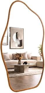Espelho orgânico dourado com moldura em couro refletindo sala de estar com sofá branco