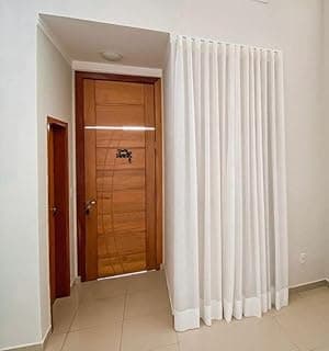 Cortina de linho branca com uma única aba pendurada em um trilho suíço em um corredor minimalista