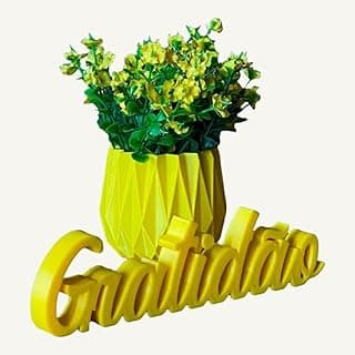 Vaso decorativo amarelo com flores e texto 'Gratidão' em fundo branco